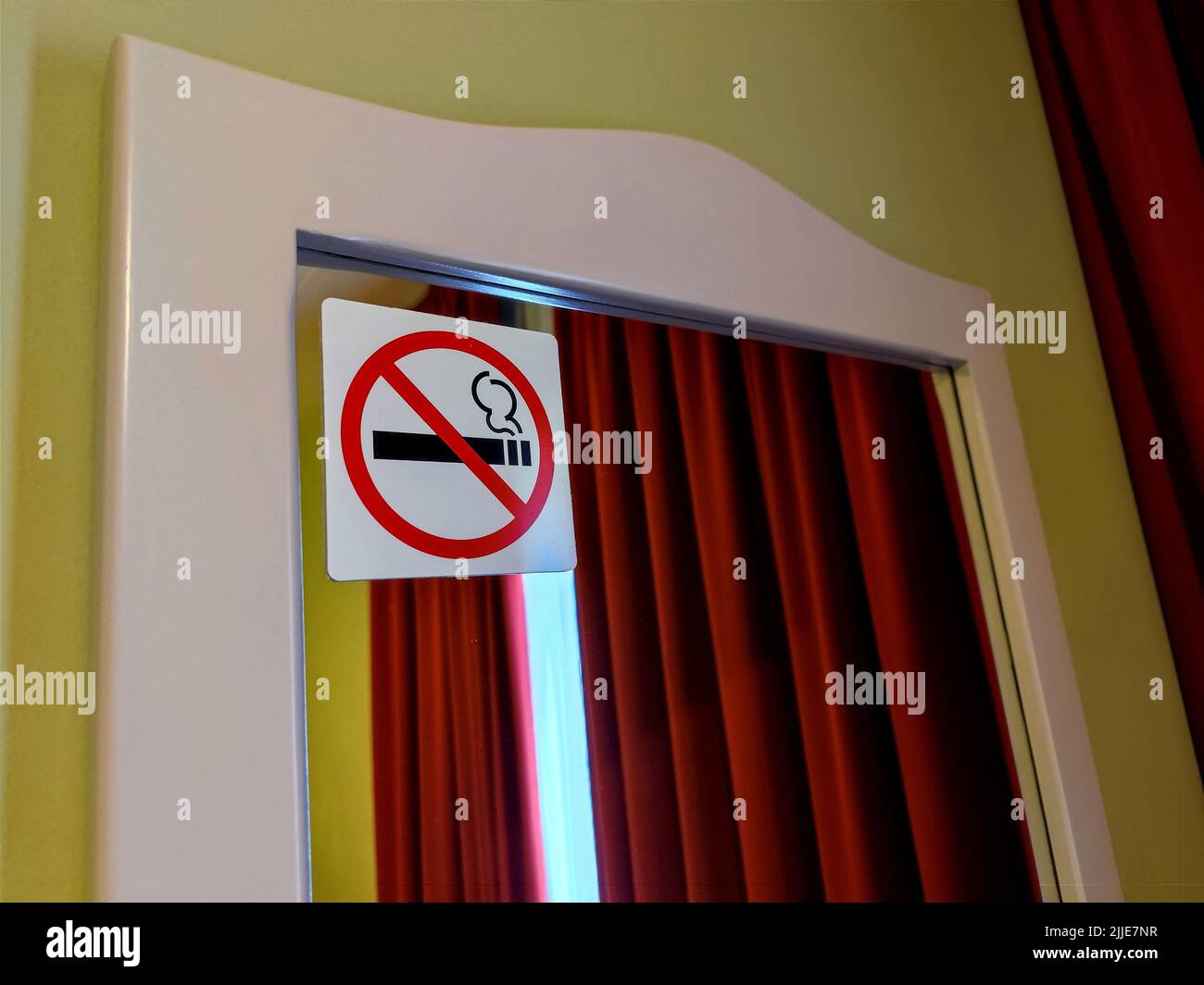 Étiquette non-fumeurs apposée sur un miroir dans une chambre d'hôtel. Il n'y a aucune personne ni marque commerciale dans la photo Banque D'Images