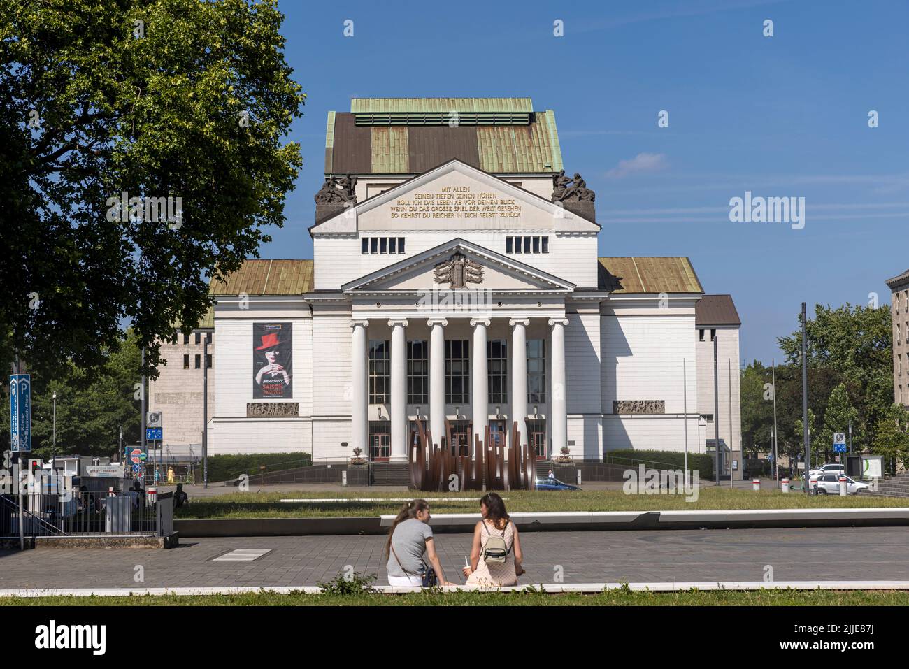 Deux femmes assises devant le théâtre Duisburg lors d'une chaude journée d'été Banque D'Images