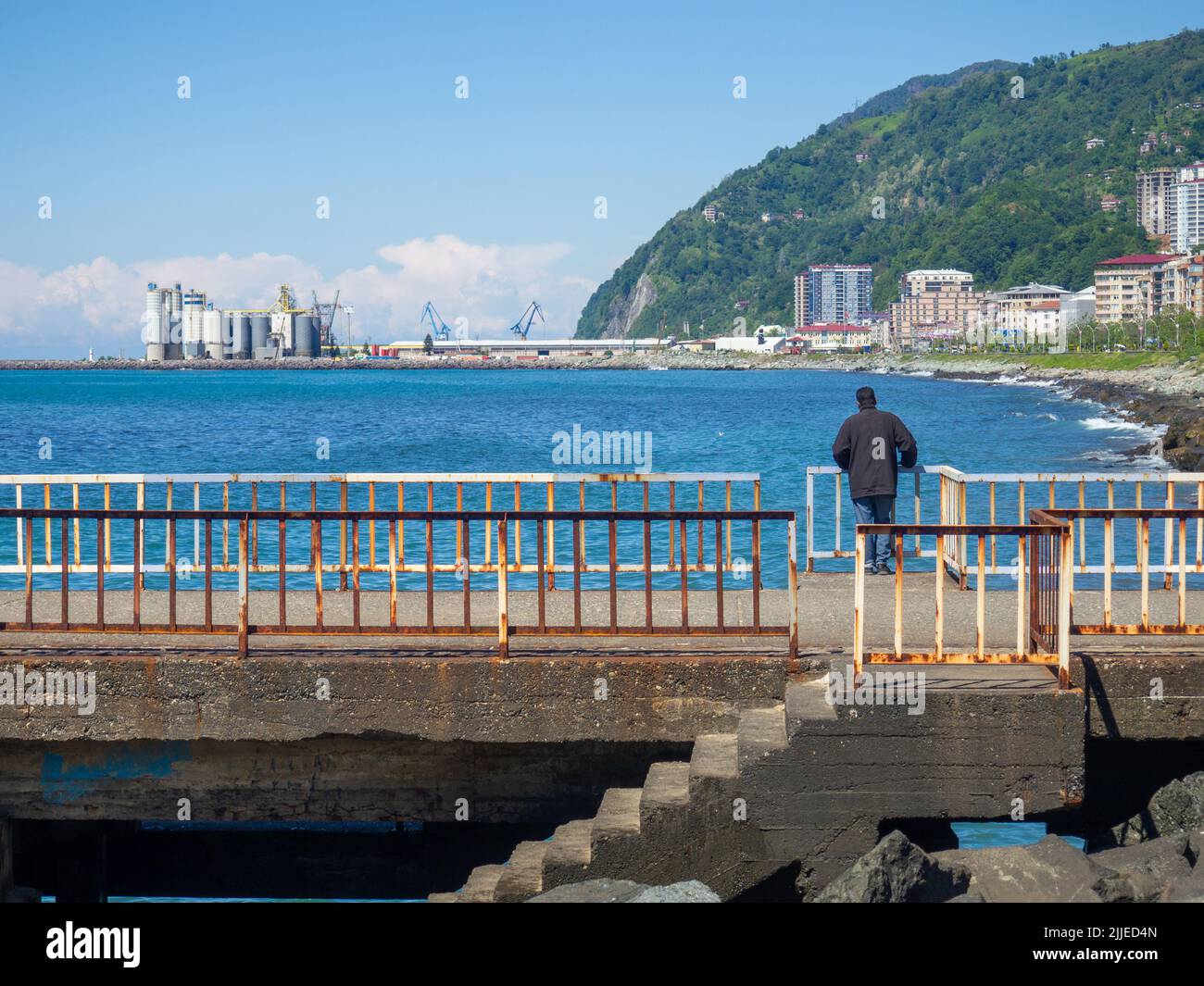 Homme solitaire sur la jetée. Reposez-vous sur la mer. Évadez-vous de la vie quotidienne. Solitude. Repos de l'agitation Banque D'Images