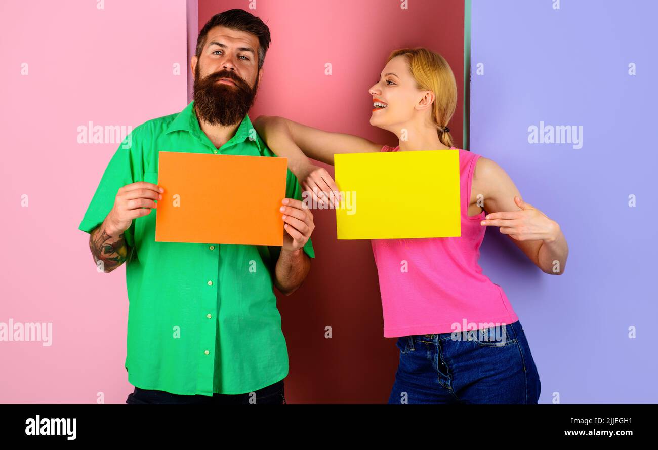 Couple présentant des tableaux de messages. Bannières publicitaires vierges. Shopping. Vente. Remise. Vendredi noir. Banque D'Images