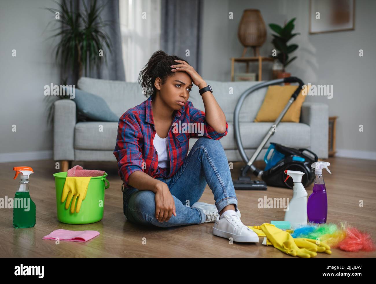 Frustré fatigué malheureux jeune femme noire femme au foyer souffrant de beaucoup de travaux ménagers s'assoient sur le sol Banque D'Images