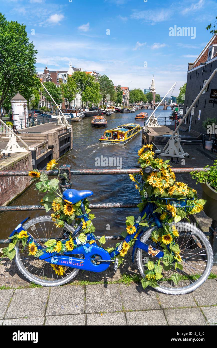 Sint Antoniesluis, sur le canal d'Oudeschans, vélo décoré de tournesols, bateau de croisière sur le canal, café, de Sluyswacht, Amsterdam, Pays-Bas Banque D'Images
