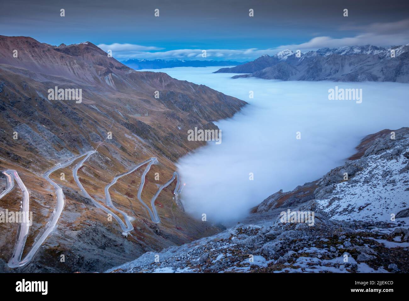 Col du Stelvio, route de montagne au-dessus des nuages brumeux dans les alpes italiennes, frontière avec la Suisse Banque D'Images