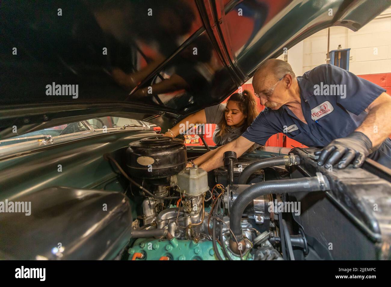 Aurora, Colorado - Cinthia Cabral et Russell Bacon remplacent le filtre à carburant d'une voiture aux mains du Carpenter. L'organisme à but non lucratif répare les véhicules appartenant à Banque D'Images