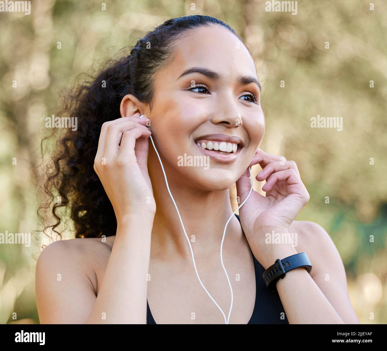 Une jeune femme sportive qui écoute de la musique tout en faisant de l'exercice à l'extérieur. Banque D'Images