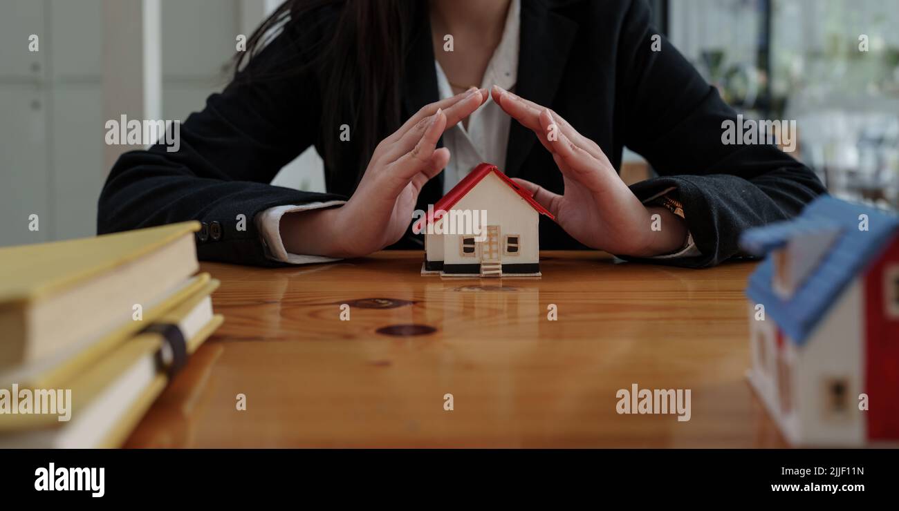 Agent courtier faisant la main pour protéger la maison. Assurance de biens et concept de sécurité. Banque D'Images