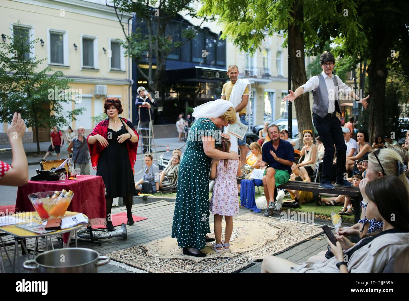 Le public regarde comme acteurs de théâtre exécuter "Odessa, je vous aime" sur le marché du livre à Odessa. La performance "Odessa, je t'aime" raconte des histoires de la vie des habitants d'Odessa avec sa couleur caractéristique et son humour. La représentation a été mise en scène par les acteurs du Théâtre n° 7 et jouée à l'extérieur sur le marché du livre. Le but de cette performance est de recueillir des dons pour les besoins de défense aérienne. Banque D'Images