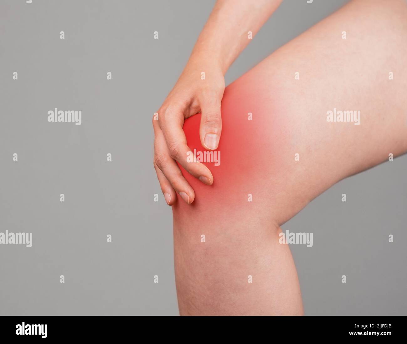 Femme tenant un genou douloureux avec une tache rouge. Douleurs articulaires. Ligaments tentainés, rompus, déchirure du ménisque, tendinite, arthrite. Problèmes de santé, conditions médicales concept. Photo de haute qualité Banque D'Images