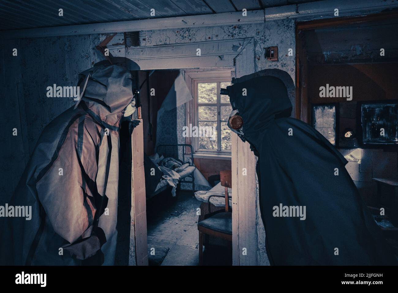 Poster de film fictif. Les gens avec des lampes de poche, des masques et des vêtements de protection inspectent la vieille maison. Personnes infectées épidémiques dans les foyers détruits. Environnement sombre et sombre, traitement du filtre. Banque D'Images