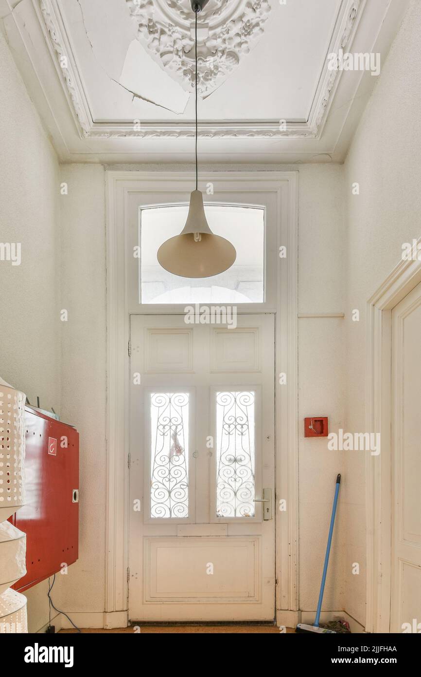 Intérieur moderne plat de style minimaliste avec couloir vide étroit éclairé par des lampes Banque D'Images