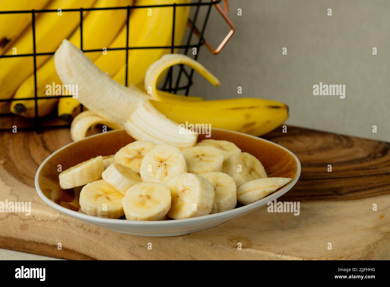 Bananes fraîches et bananes coupées en morceaux dans un bol sur la table - photo de stock Banque D'Images