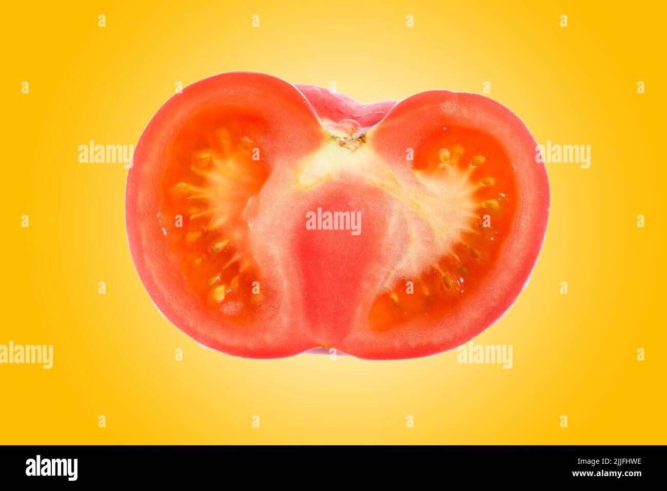 Gros plan d'une demi-tranche de tomates rouges fraîches et biologiques sur un fond orange vif et dégradé. Banque D'Images