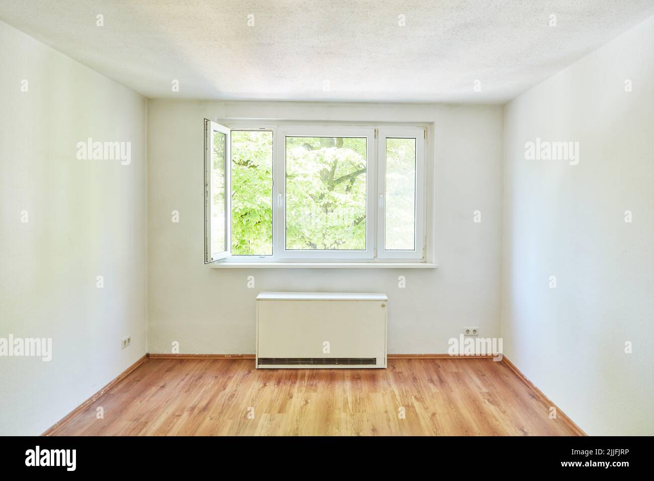 Chambre vide avec chauffage et une fenêtre ouverte dans un appartement Banque D'Images