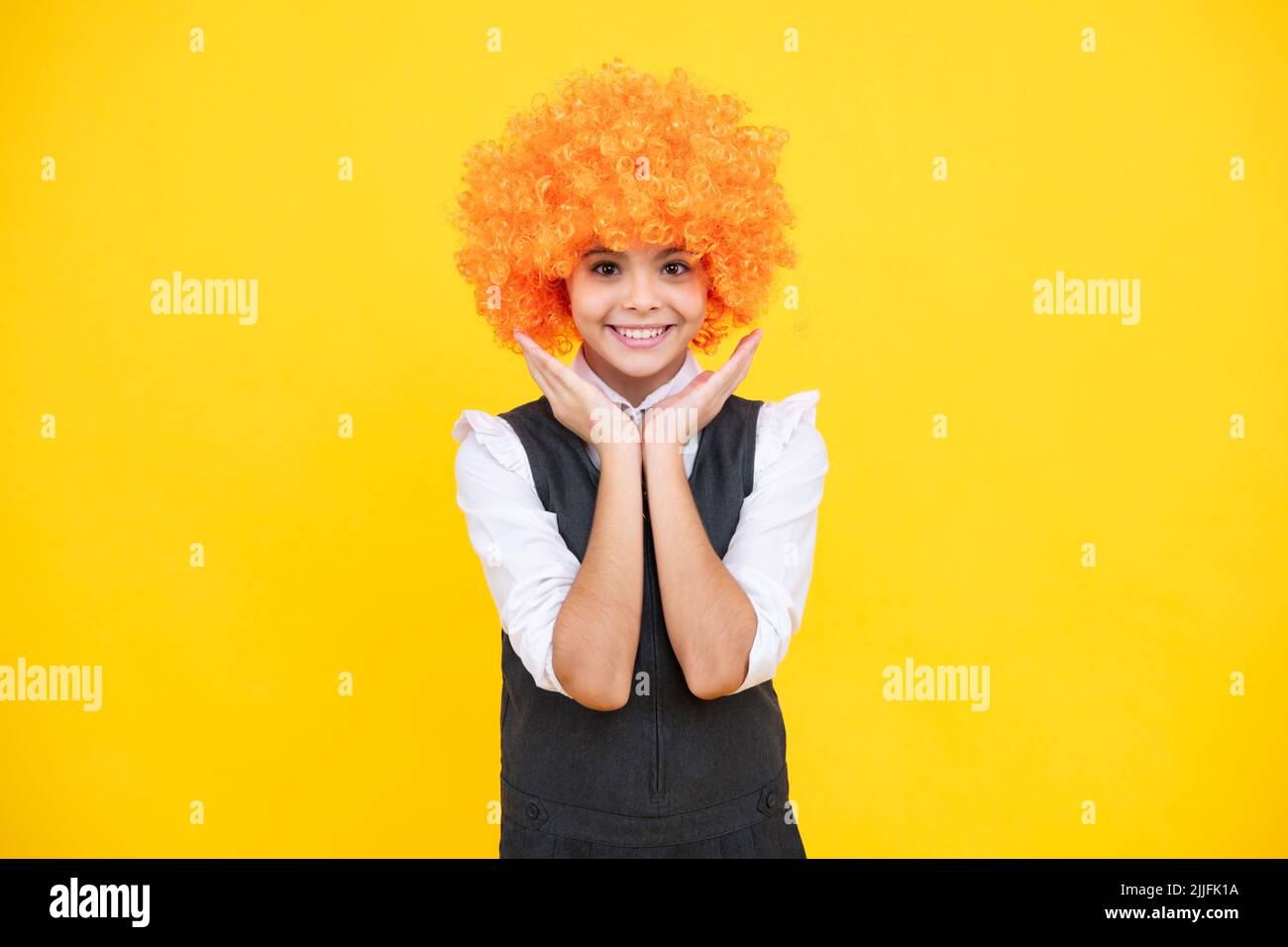 Fête d'anniversaire pour filles. Drôle d'enfant dans la perruque rouge curly. Temps de Amuse-toi bien. Jeune fille avec des cheveux orange, étant un clown. Bonne fille visage, positif et Banque D'Images