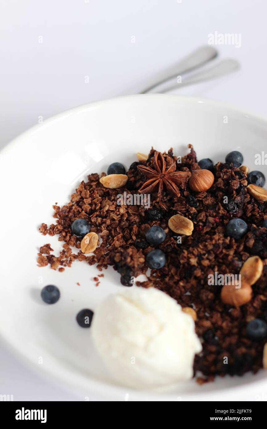 Céréales aux myrtilles servies avec une cuillère de crème glacée. Simple dessert maison. Banque D'Images