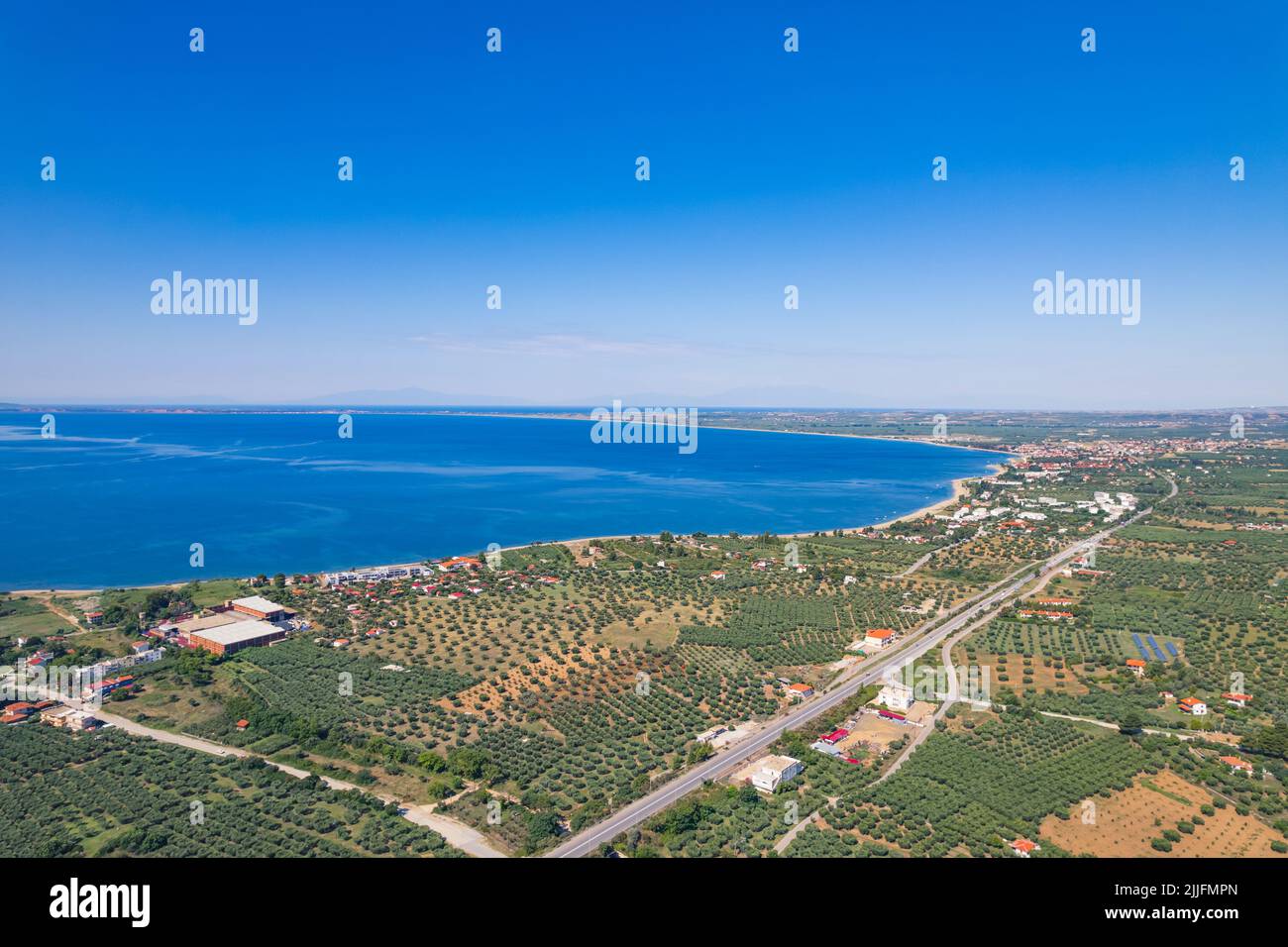 Magnifique bord de mer naturel en Grèce. Ciel bleu clair et mer. Zone légèrement peuplée, maisons blanchies à la chaux de style grec aux toits orange. Photo de haute qualité Banque D'Images