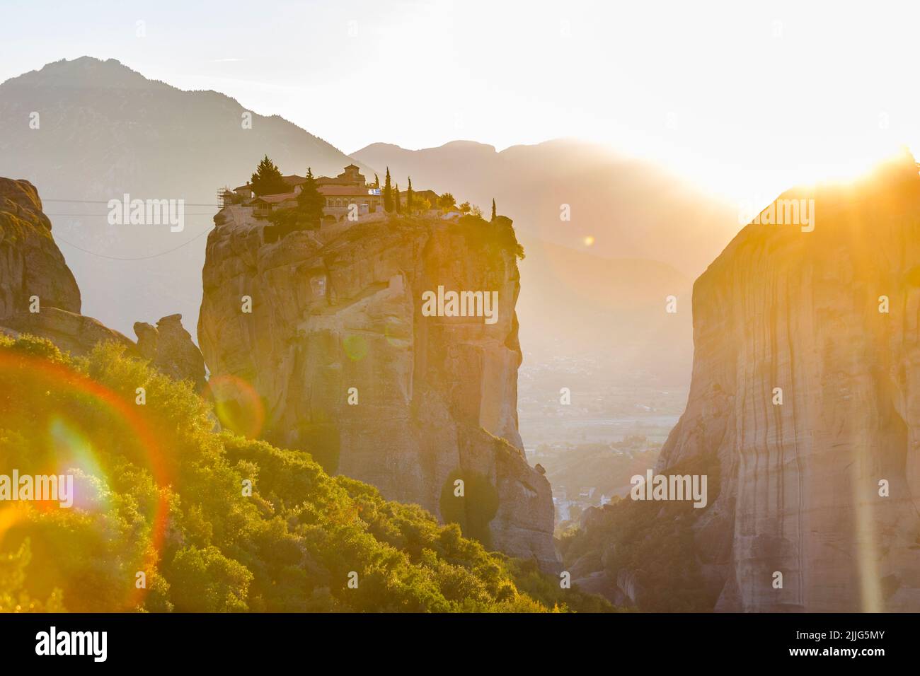 Le monastère grec miraculeux dans une lumière du soleil sur la formation rocheuse au coucher du soleil, Meteora, Grèce. Mystérieuse pendaison sur des monastères de rochers près de Kal Banque D'Images