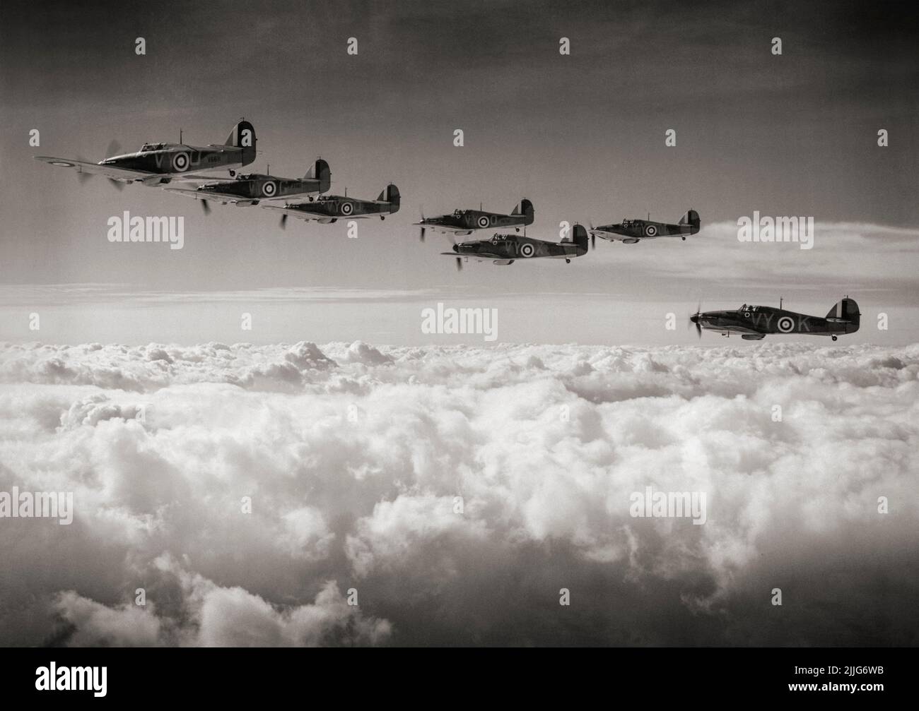 Une formation de Hawker Hurricane Mark est de l'escadron no 85 RAF basé à Church Fenton, dans le Yorkshire, monte au-dessus des nuages, dirigé par le chef d'escadron Peter H Townsend. L'ouragan, un chasseur britannique à siège unique des 1930s–40s, a été éclipsé dans la conscience publique par le Spitfire Supermarine pendant la bataille d'Angleterre en 1940, mais l'ouragan a infligé 60 pour cent des pertes subies par la Luftwaffe dans l'engagement, Et a combattu dans tous les grands théâtres de la Seconde Guerre mondiale. Banque D'Images