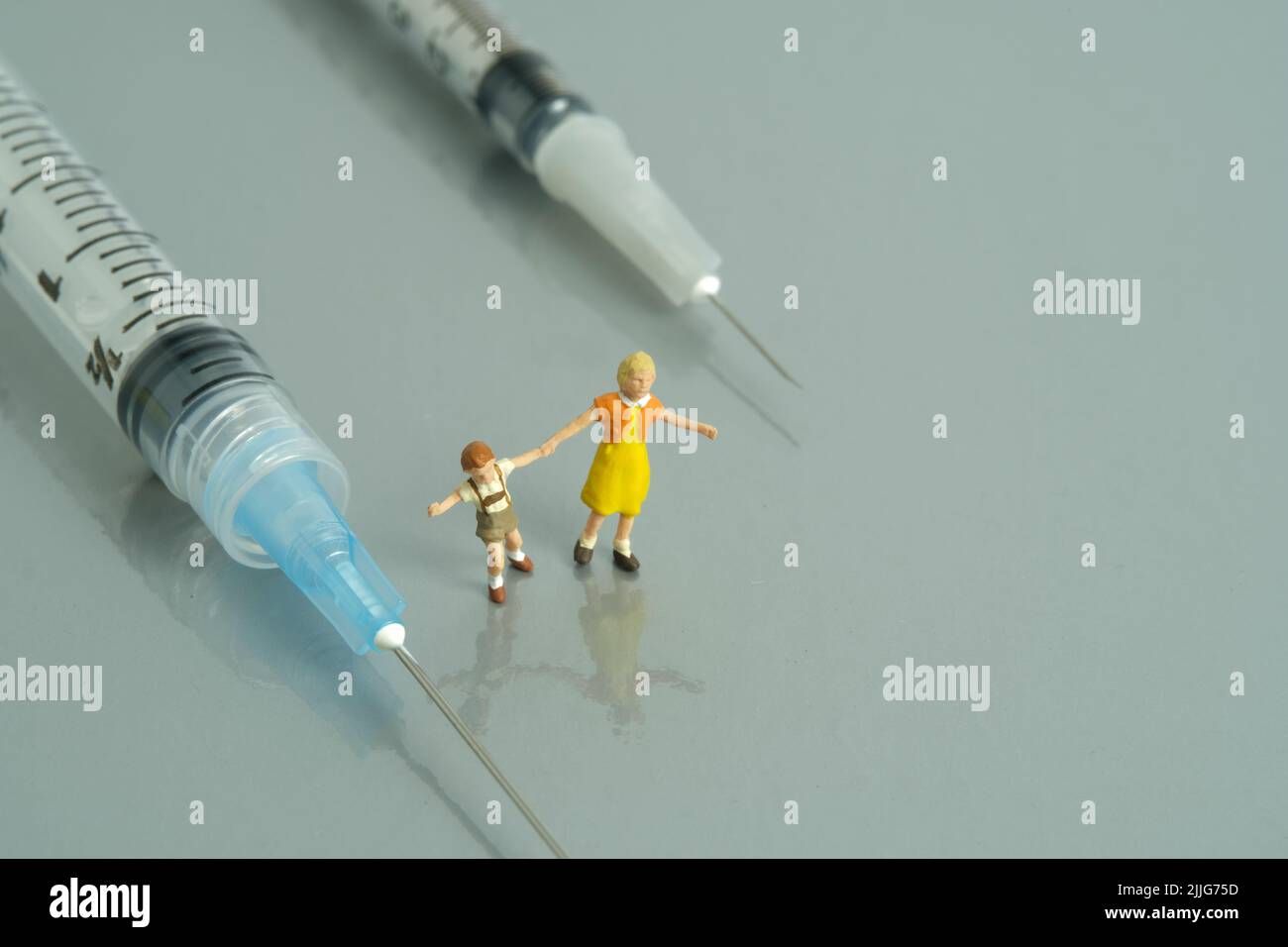 Photographie miniature de personnage de jouet de personnes. Concept de vaccination des enfants. Un enfant jouant à côté d'une seringue. Photo d'image Banque D'Images