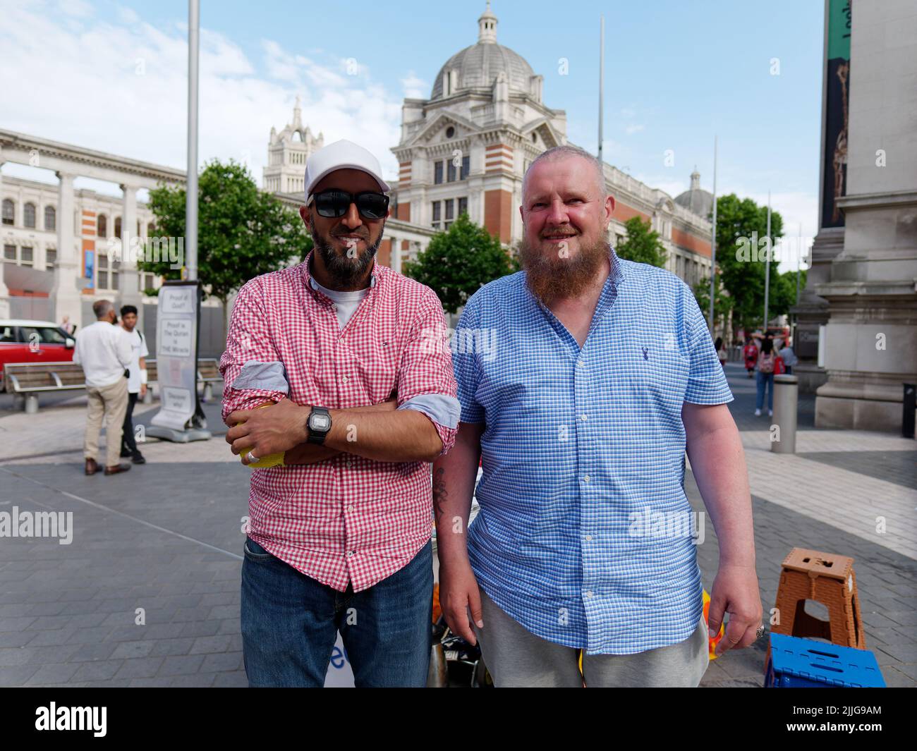 Londres, Grand Londres, Angleterre, 15 juin 2022 : deux hommes barbus dont un avec des lunettes de soleil et une casquette sourient et posent pour une photo sur Exhibition Road. Banque D'Images