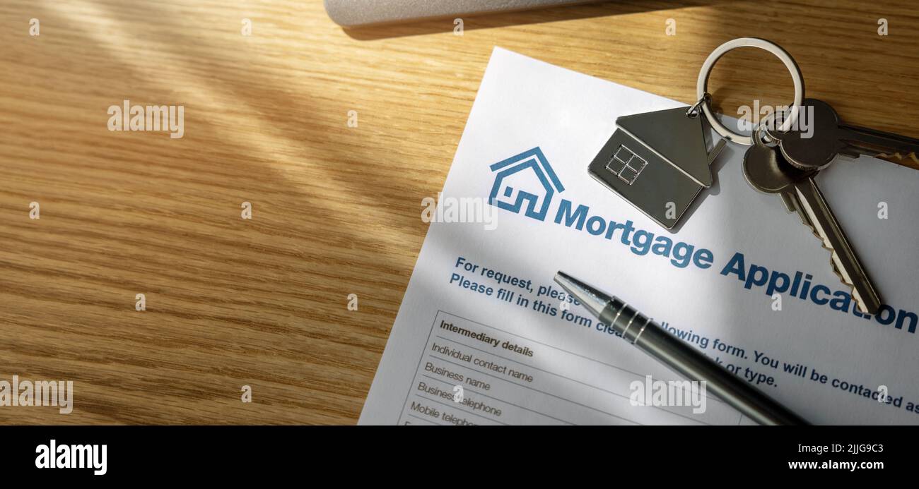 formulaire de demande de prêt hypothécaire et nouvelles clés à la maison sur la table du bureau de la banque Banque D'Images
