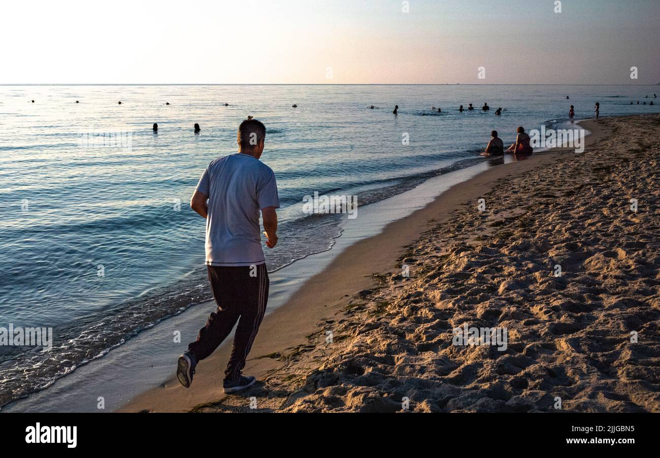 Un homme court à l'aube le long de la plage près de Port El Kantaoui en Tunisie Banque D'Images