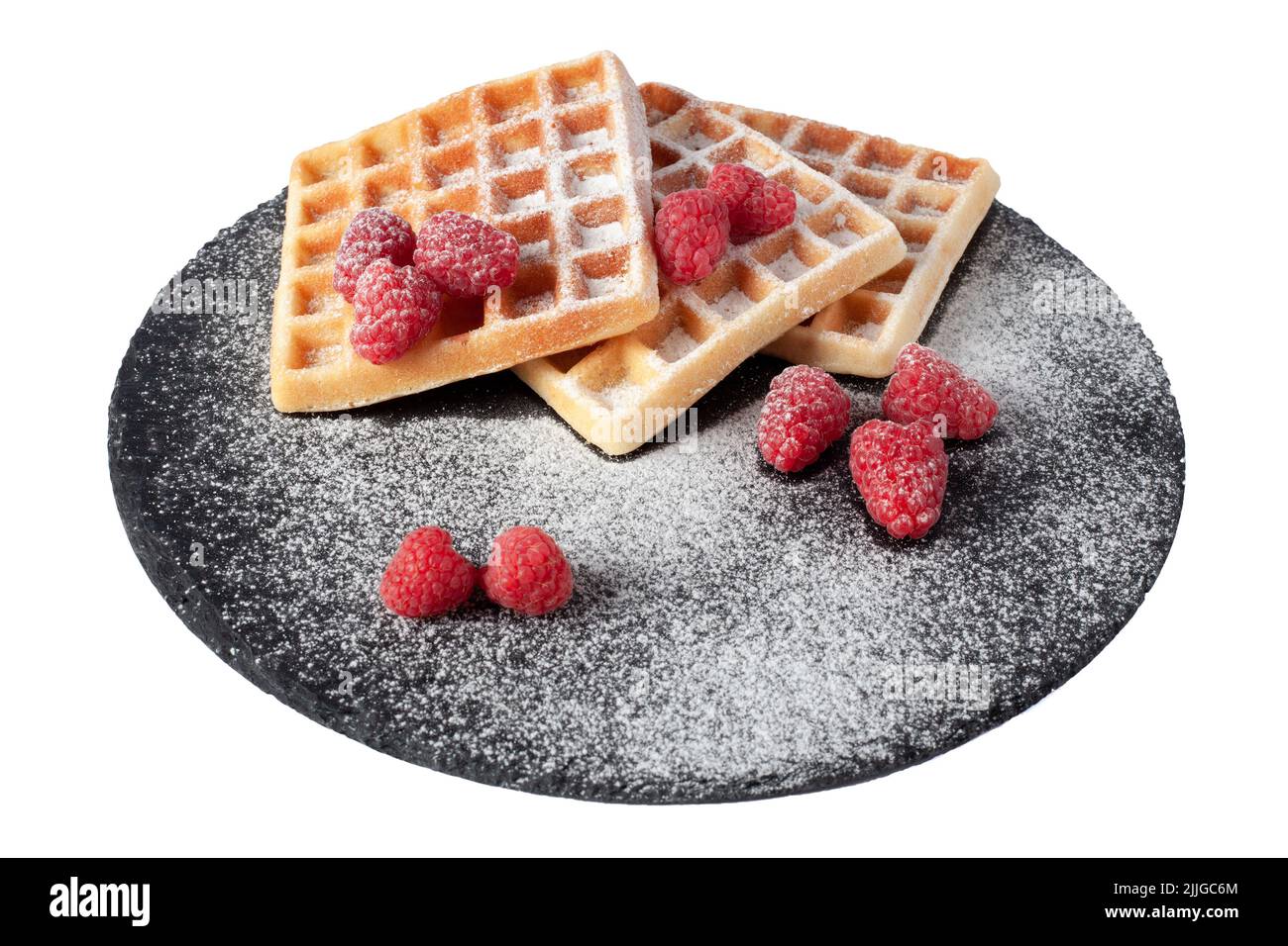 Gaufres maison avec baies et sucre en poudre sur plaque de pierre noire isolée. Gaufre belge avec framboise sur fond blanc Banque D'Images