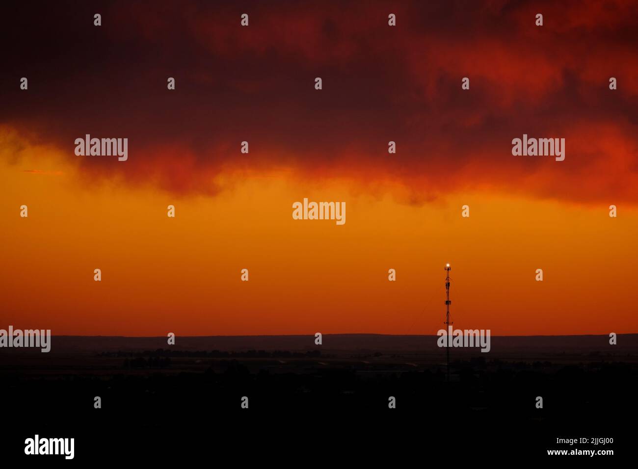 Silhouette de tour de cellules au coucher du soleil sur la ligne d'horizon pour la communication numérique Banque D'Images