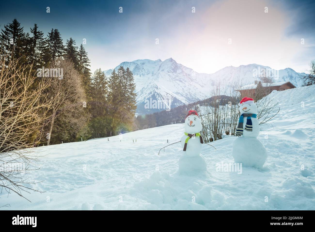 Deux bonhommes de neige construisent avec un chapeau de carotte et un foulard sur les montagnes Banque D'Images