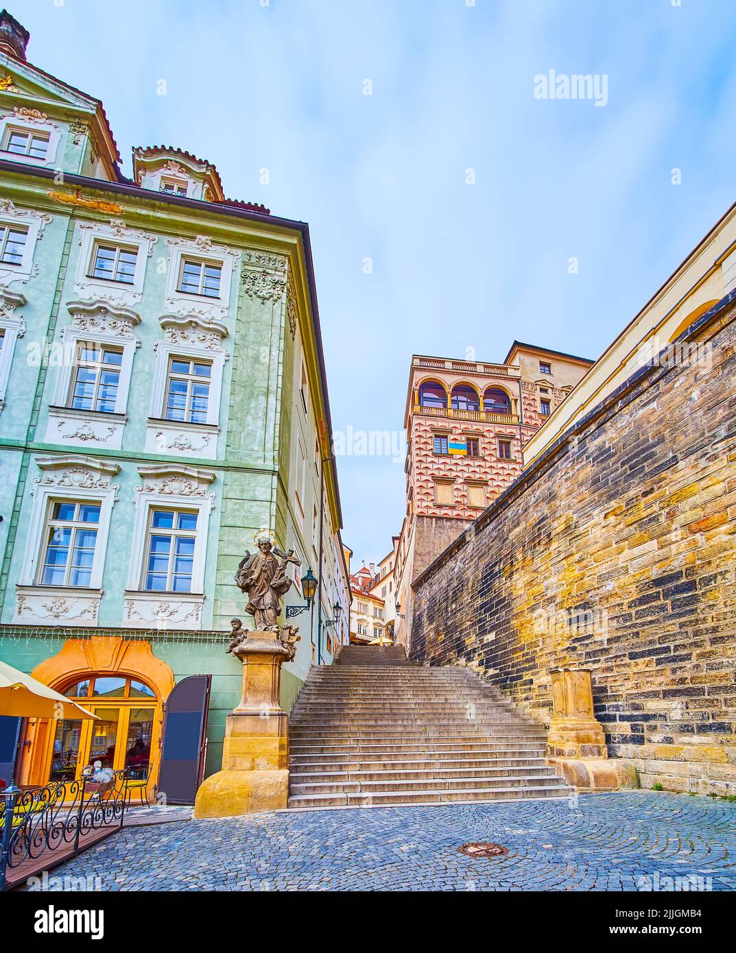 Rue en pierre historique de Radnicke Schody (escalier de Radnicke) avec statue de St Jogn Nepomuk et mur vert de la maison à l'étoile d'or, Hradcany, Prague Banque D'Images