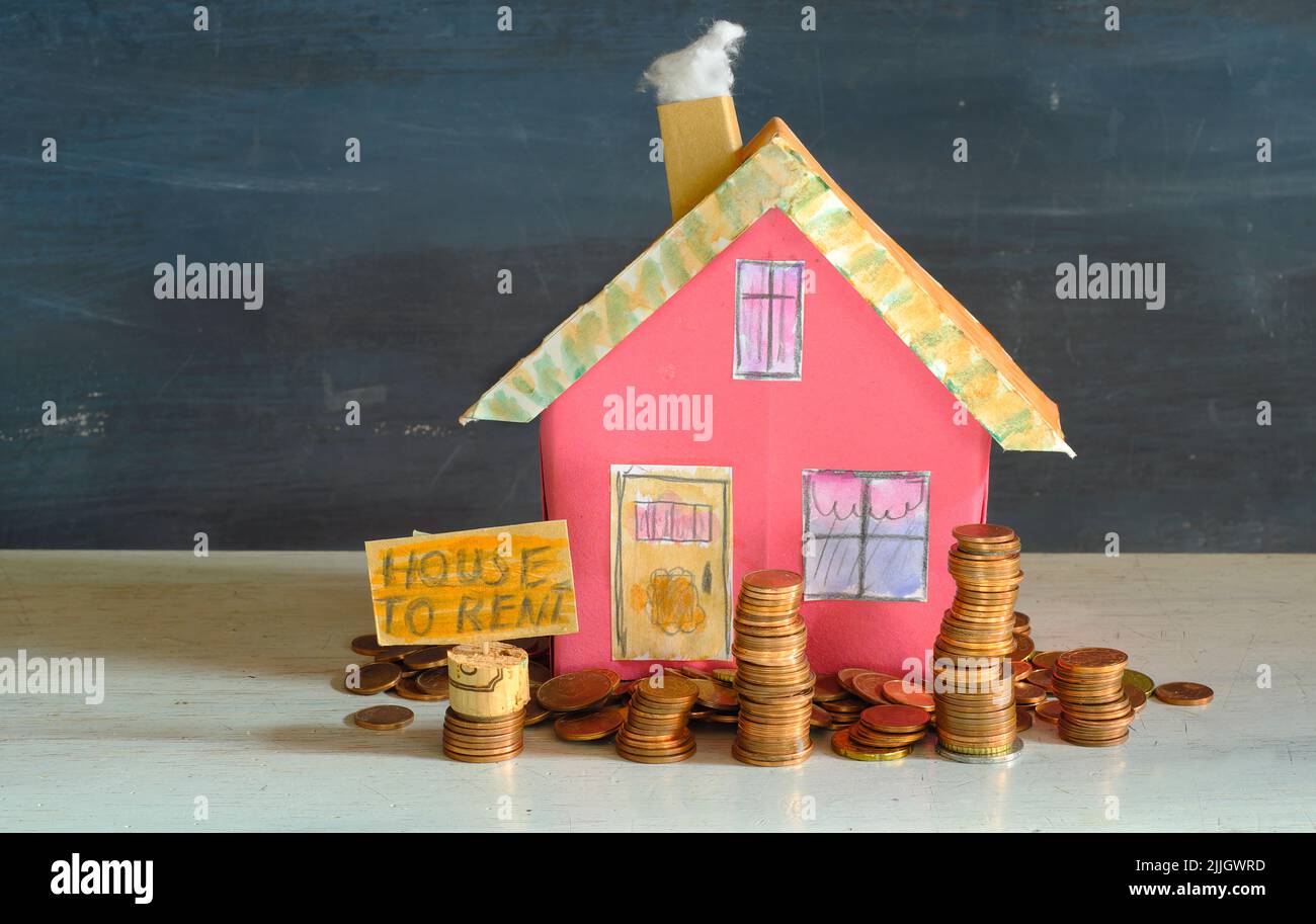 augmentation des loyers pour la maison, modèle de maison avec de l'argent empilé conceptuel, image symbolique Banque D'Images