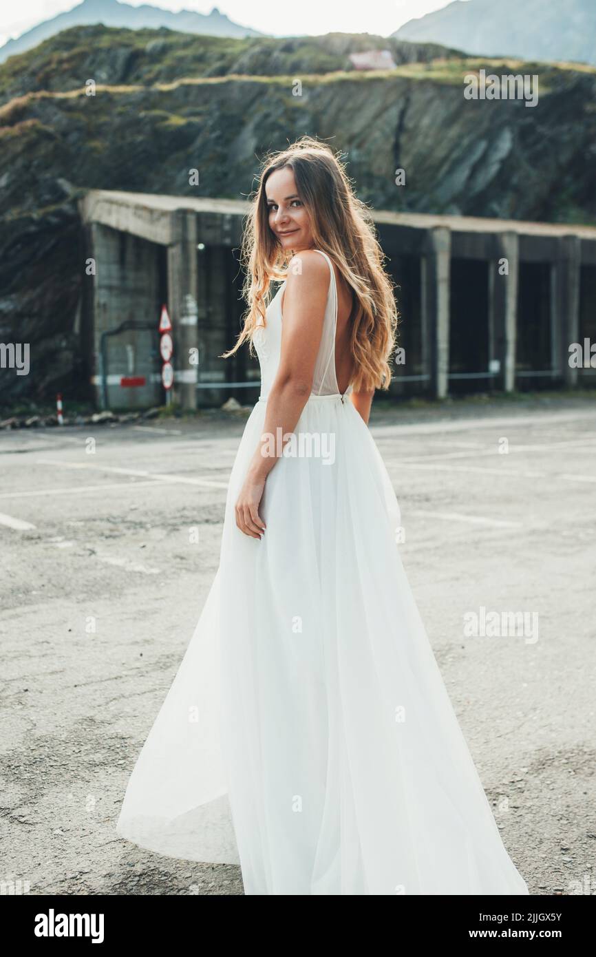 La mariée s'est arrêtée pour prendre une photo pendant qu'elle marche dans  une robe de mariage sur la route des montagnes. Modèle de mode. Route de  montagne Photo Stock - Alamy