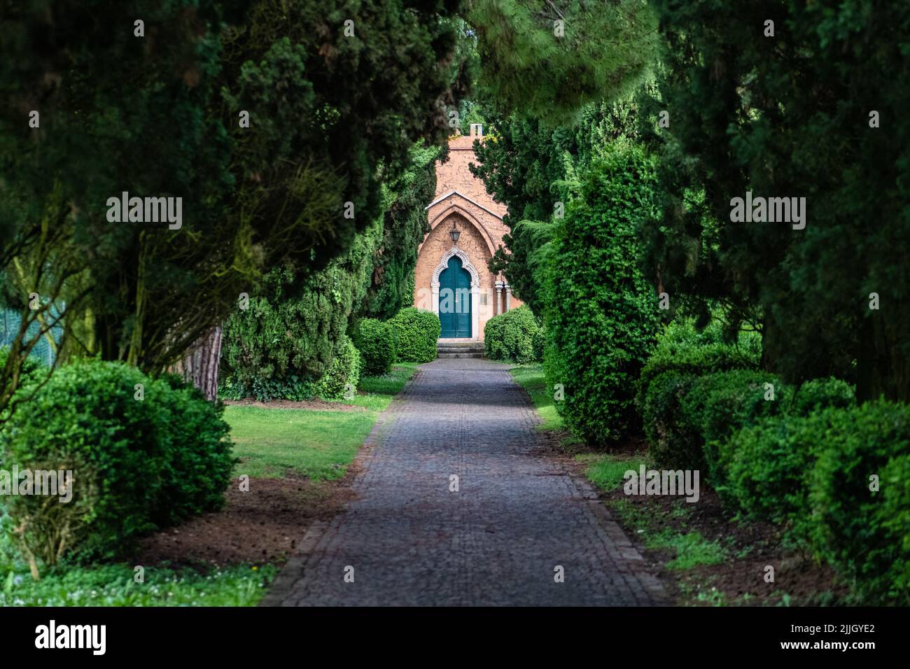 L'allée à travers un parc de jardin entouré de buissons verts et d'arbres dans le nord de l'Italie Banque D'Images