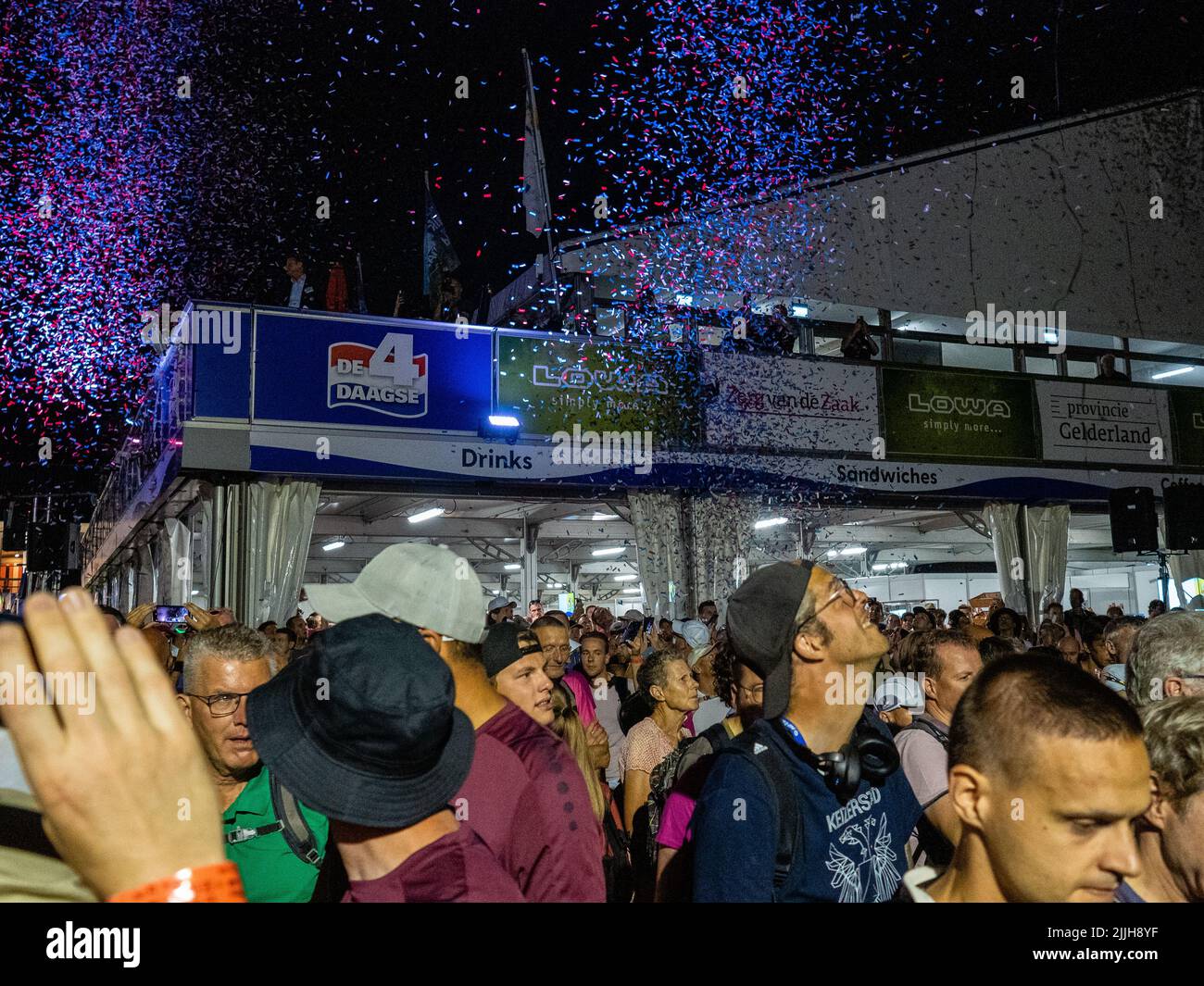 Les participants regardent les confetti au signal de départ lors du plus grand événement de marche de plusieurs jours au monde. La marche des quatre jours (en néerlandais 'Vierdaagse') est considérée comme le premier exemple de l'esprit sportif et des liens internationaux entre militaires et civils de nombreux pays différents. Après deux ans d'annulation, il a été retenu à nouveau, mais le premier jour a été annulé en raison de températures chaudes, transformant les quatre marches en trois jours de marche. Il s'agit de l'édition 104 et le total officiel des marcheurs enregistrés était de 38 455 dans 69 pays. Ils peuvent choisir de marcher 30km, 40km ou 50km p. Banque D'Images