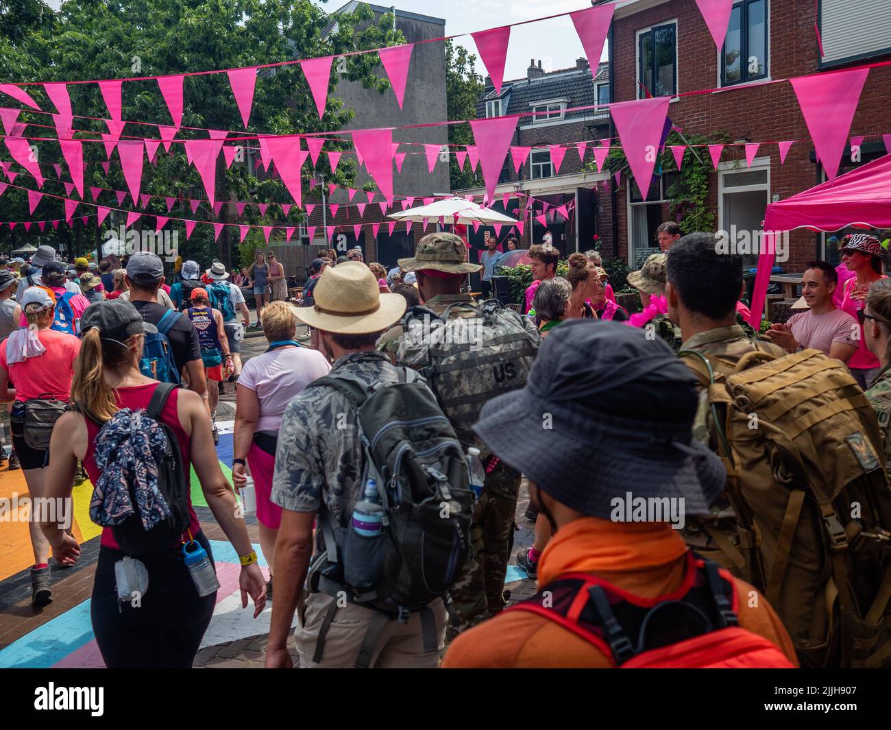 Les participants arrivent dans un quartier décoré de drapeaux roses lors du plus grand événement de randonnée de plusieurs jours au monde. La marche des quatre jours (en néerlandais 'Vierdaagse') est considérée comme le premier exemple de l'esprit sportif et des liens internationaux entre militaires et civils de nombreux pays différents. Après deux ans d'annulation, il a été retenu à nouveau, mais le premier jour a été annulé en raison de températures chaudes, transformant les quatre marches en trois jours de marche. Il s'agit de l'édition 104 et le total officiel des marcheurs enregistrés était de 38 455 dans 69 pays. Ils peuvent choisir de marcher 3 Banque D'Images