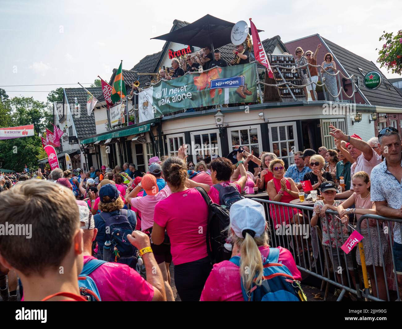 Un groupe de musique est vu jouer pour les marcheurs sur un toit lors du plus grand événement de marche de plusieurs jours au monde. La marche des quatre jours (en néerlandais 'Vierdaagse') est considérée comme le premier exemple de l'esprit sportif et des liens internationaux entre militaires et civils de nombreux pays différents. Après deux ans d'annulation, il a été retenu à nouveau, mais le premier jour a été annulé en raison de températures chaudes, transformant les quatre marches en trois jours de marche. Il s'agit de l'édition 104 et le total officiel des marcheurs enregistrés était de 38 455 dans 69 pays. Ils peuvent choisir de marcher 30km, 40km ou 50km p. Banque D'Images