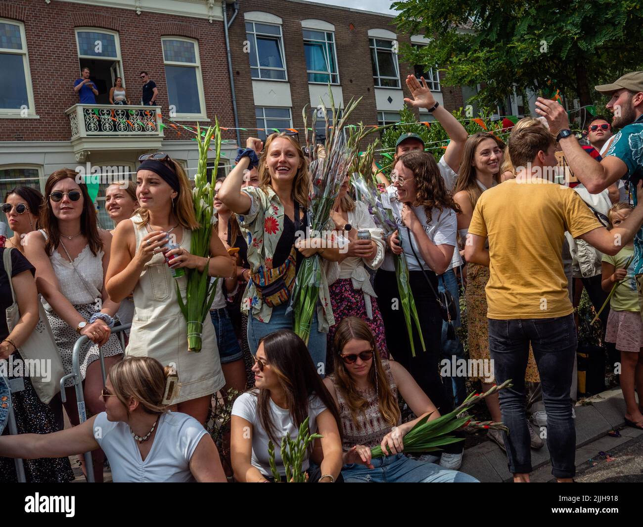 Une foule de personnes tenant du gladiolus applaudit les marcheurs lors du plus grand événement de randonnée de plusieurs jours au monde. La marche des quatre jours (en néerlandais 'Vierdaagse') est considérée comme le premier exemple de l'esprit sportif et des liens internationaux entre militaires et civils de nombreux pays différents. Après deux ans d'annulation, il a été retenu à nouveau, mais le premier jour a été annulé en raison de températures chaudes, transformant les quatre marches en trois jours de marche. Il s'agit de l'édition 104 et le total officiel des marcheurs enregistrés était de 38 455 dans 69 pays. Ils peuvent choisir de marcher 30km, 40km ou 50km par jour Banque D'Images