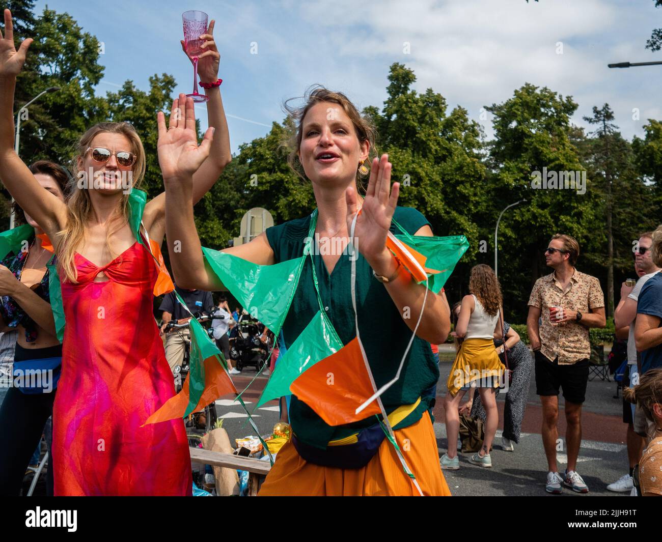 Les femmes applaudissent les marcheurs qui passent à côté lors du plus grand événement de marche de plusieurs jours au monde. La marche des quatre jours (en néerlandais 'Vierdaagse') est considérée comme le premier exemple de l'esprit sportif et des liens internationaux entre militaires et civils de nombreux pays différents. Après deux ans d'annulation, il a été retenu à nouveau, mais le premier jour a été annulé en raison de températures chaudes, transformant les quatre marches en trois jours de marche. Il s'agit de l'édition 104 et le total officiel des marcheurs enregistrés était de 38 455 dans 69 pays. Ils peuvent choisir de marcher 30km, 40km ou 50km par jour. Banque D'Images