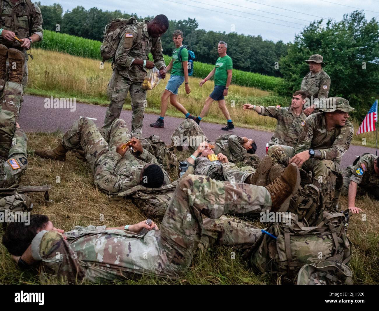 Un groupe de militaires prend une pause lors du plus grand événement de marche de plusieurs jours au monde. La marche des quatre jours (en néerlandais 'Vierdaagse') est considérée comme le premier exemple de l'esprit sportif et des liens internationaux entre militaires et civils de nombreux pays différents. Après deux ans d'annulation, il a été retenu à nouveau, mais le premier jour a été annulé en raison de températures chaudes, transformant les quatre marches en trois jours de marche. Il s'agit de l'édition 104 et le total officiel des marcheurs enregistrés était de 38 455 dans 69 pays. Ils peuvent choisir de marcher 30km, 40km ou 50km par jour. Banque D'Images