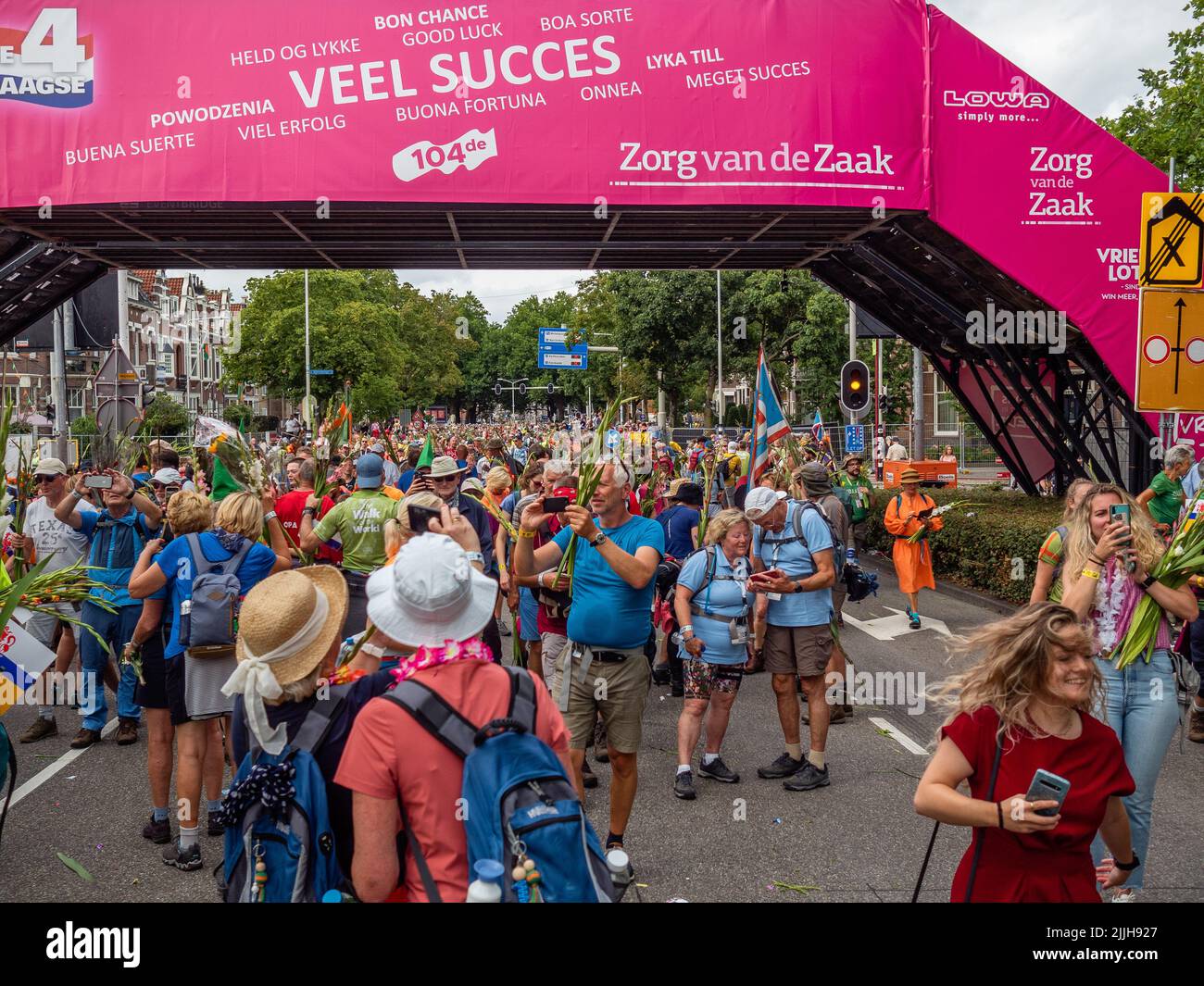 Les participants prennent un selfie à la ligne d'arrivée du plus grand événement de marche de plusieurs jours au monde. La marche des quatre jours (en néerlandais 'Vierdaagse') est considérée comme le premier exemple de l'esprit sportif et des liens internationaux entre militaires et civils de nombreux pays différents. Après deux ans d'annulation, il a été retenu à nouveau, mais le premier jour a été annulé en raison de températures chaudes, transformant les quatre marches en trois jours de marche. Il s'agit de l'édition 104 et le total officiel des marcheurs enregistrés était de 38 455 dans 69 pays. Ils peuvent choisir de marcher 30km, 40km ou 50km par jour. Banque D'Images