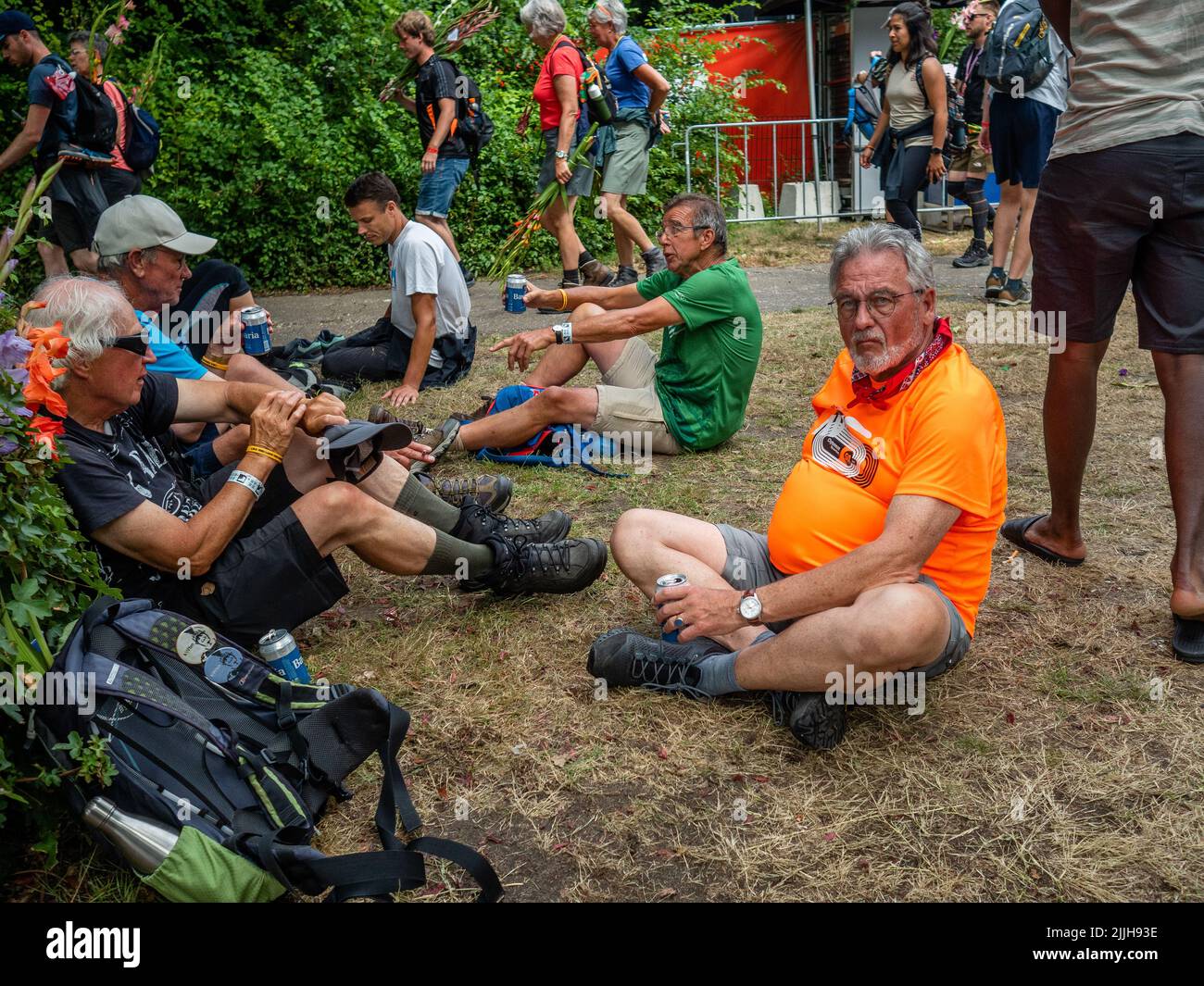 Les participants se reposent sur l'herbe après avoir franchi la ligne d'arrivée du plus grand événement de marche de plusieurs jours au monde. La marche des quatre jours (en néerlandais 'Vierdaagse') est considérée comme le premier exemple de l'esprit sportif et des liens internationaux entre militaires et civils de nombreux pays différents. Après deux ans d'annulation, il a été retenu à nouveau, mais le premier jour a été annulé en raison de températures chaudes, transformant les quatre marches en trois jours de marche. Il s'agit de l'édition 104 et le total officiel des marcheurs enregistrés était de 38 455 dans 69 pays. Ils peuvent choisir de marcher 30km, 40km, ou Banque D'Images