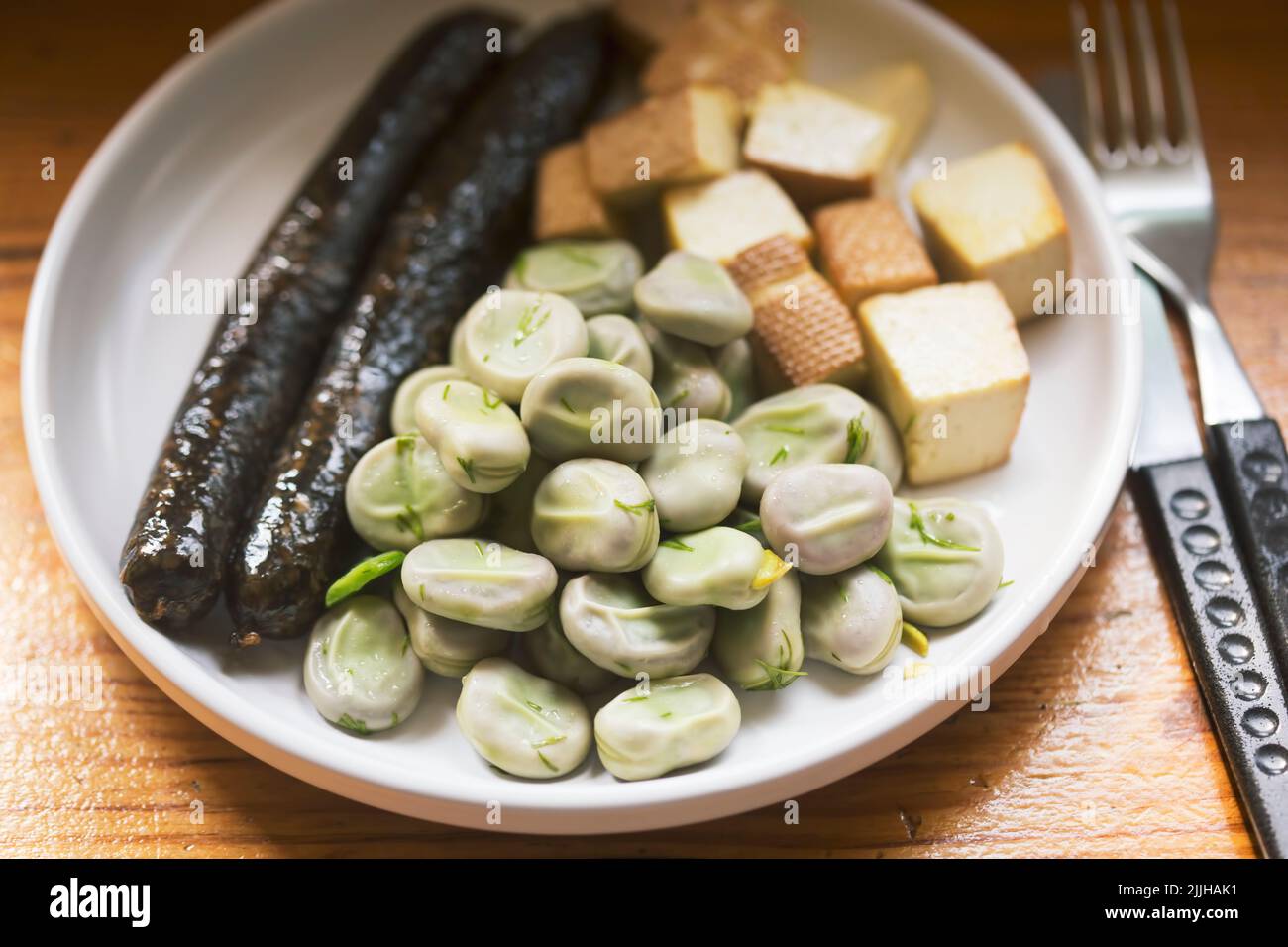 Fèves avec aneth et beurre avec saucisse au pudding noir Banque D'Images
