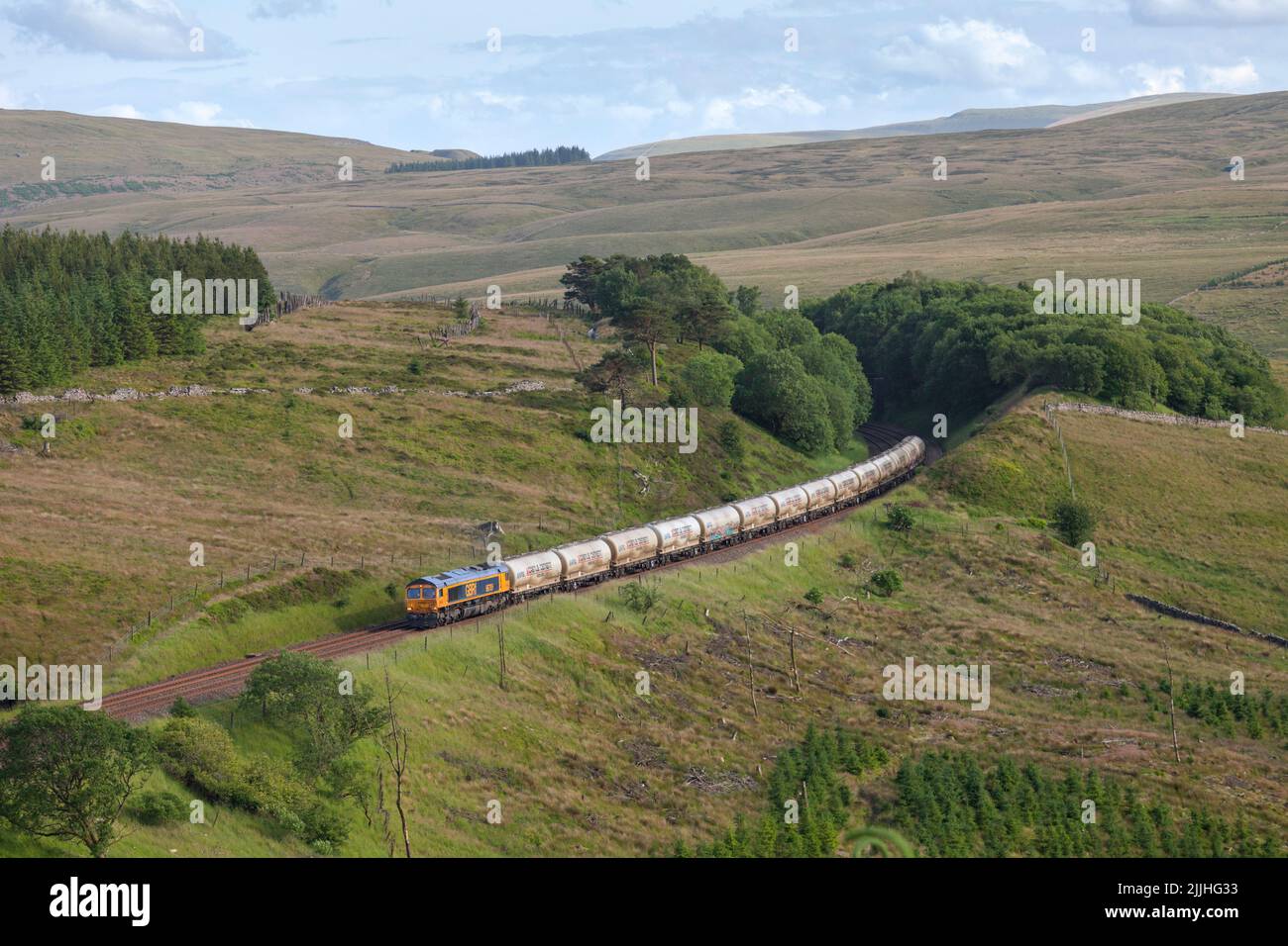 GB Railfreight classe 66 locomotive dans la campagne sur la pittoresque établir à la ligne de chemin de fer de Carlisle près de Dent avec un train de fret de ciment en vrac Banque D'Images