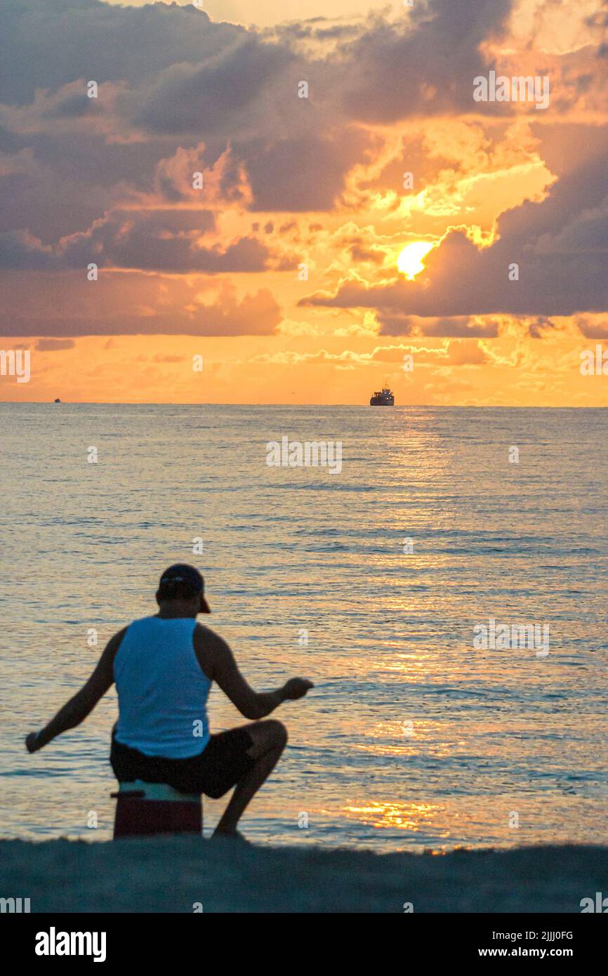 Miami Beach Floride, côte Atlantique océan Atlantique littoral, hispanique latin Latino ethnique adultes homme hommes, pêche de surf au lever du soleil nuages Banque D'Images