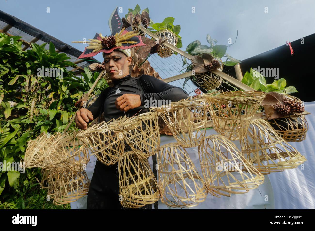 Une femme en robe nature à base de feuilles, fleurs, racines, participe à un défilé de mode nature « Retour à la nature préservation culturelle » Banque D'Images