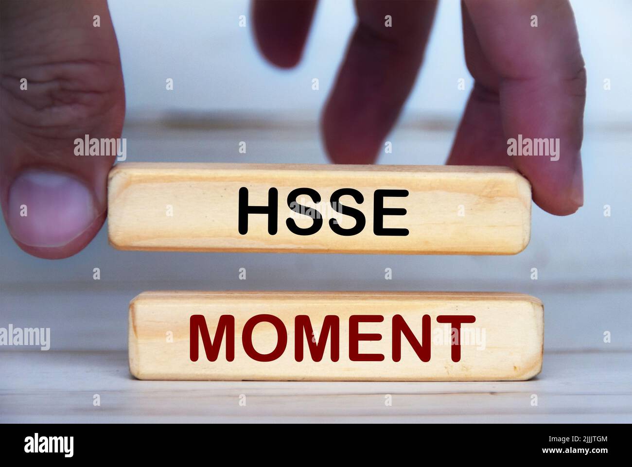 Main tenant des blocs de bois avec texte - moment HSSE. Concept de santé, sécurité, sécurité et environnement Banque D'Images