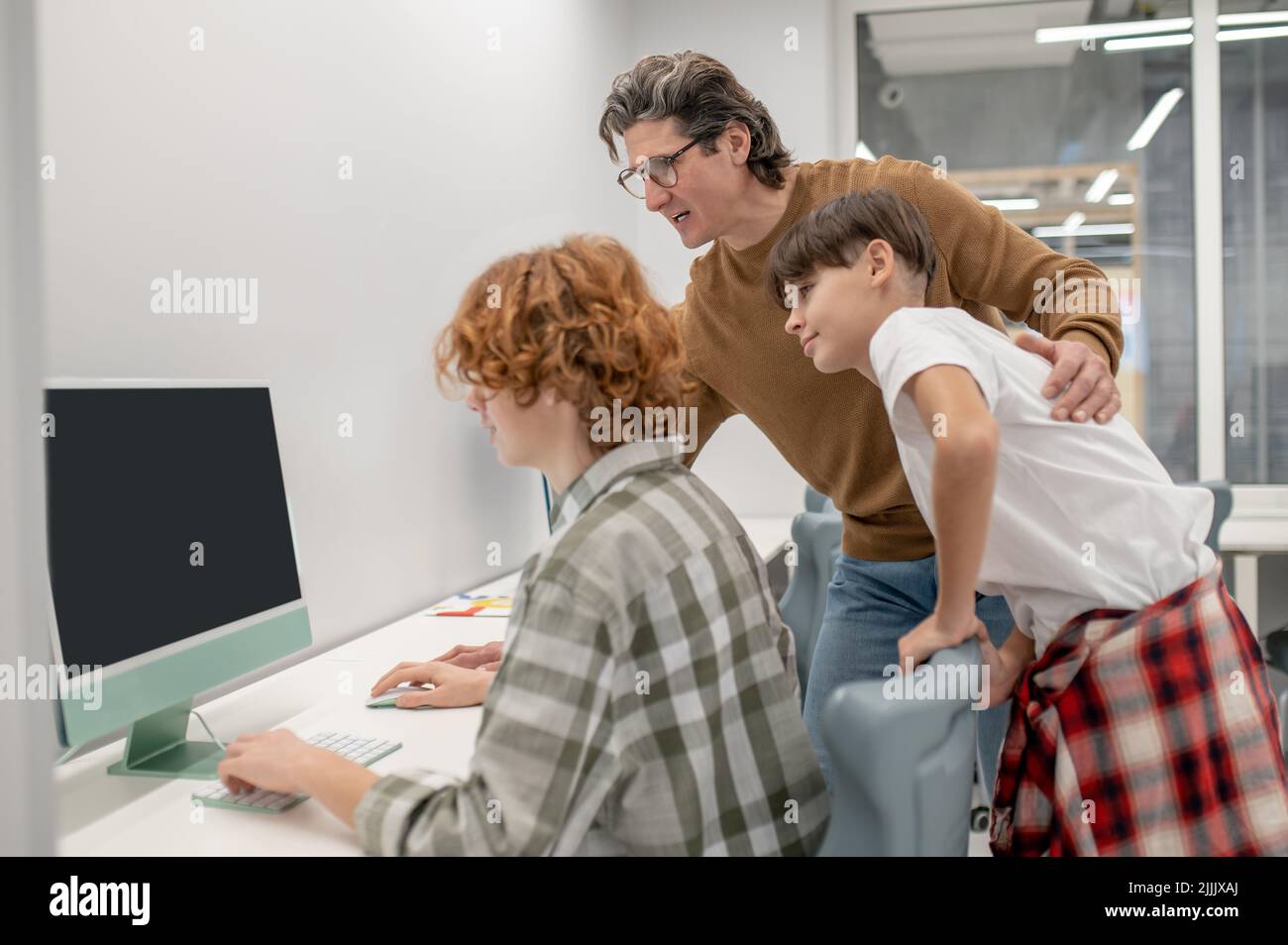 Les écoliers et leur enseignant aux ordinateurs dans une salle de classe Banque D'Images