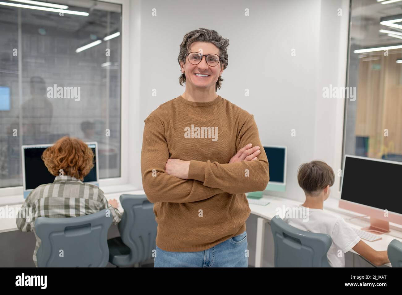 Les écoliers et leur enseignant aux ordinateurs dans une salle de classe Banque D'Images
