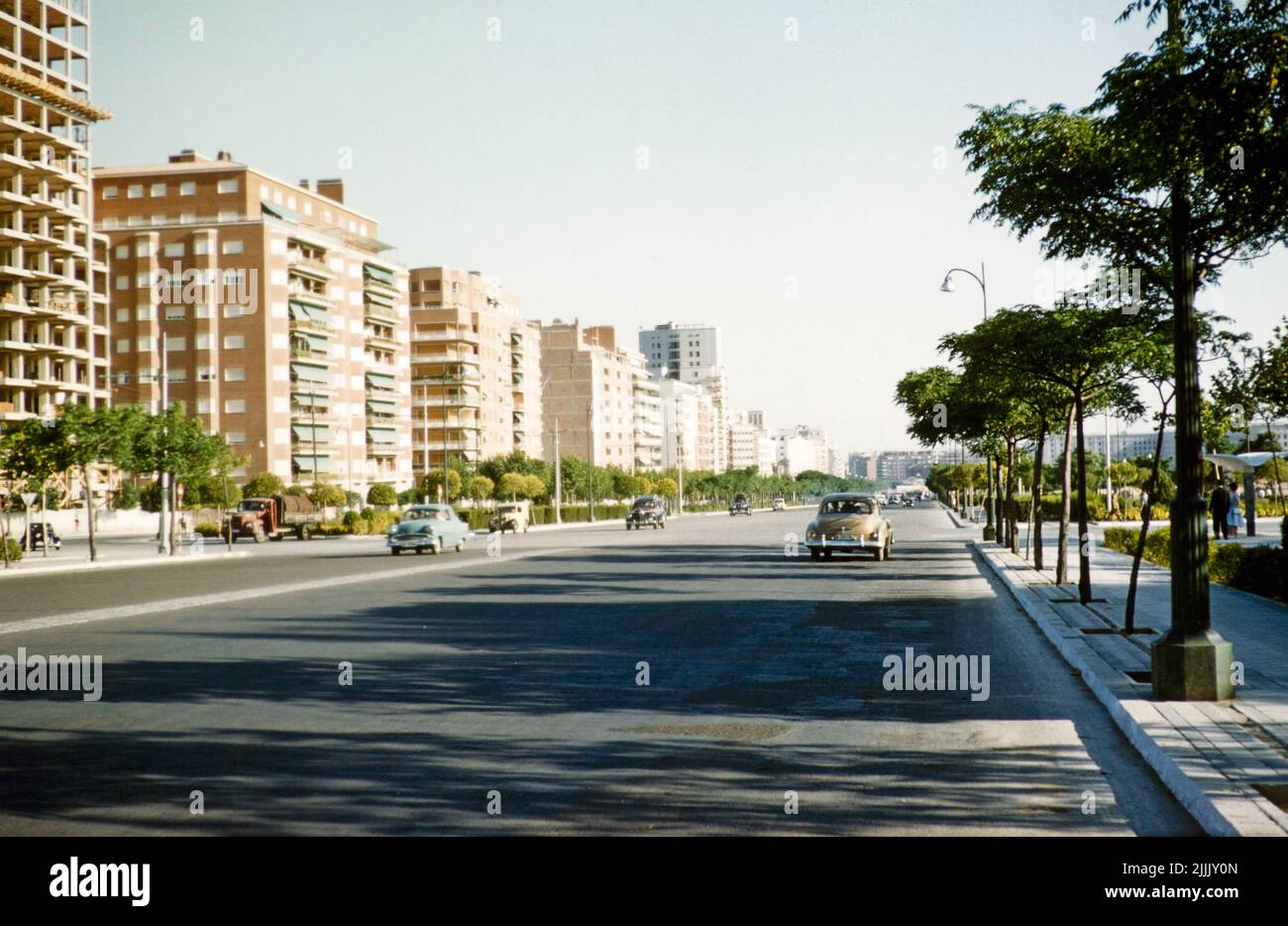 Large avenue tranquille avec peu de voitures dans le quartier moderne de logement de banlieue des immeubles, Madrid, Espagne 1959 Banque D'Images