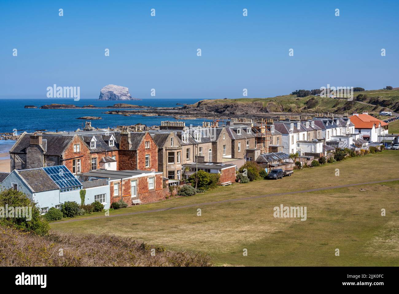 Maisons sur Marine Parade, avec la colonie d'oiseaux de mer de Bass Rock à distance, sur le front de mer de la ville côtière de North Berwick à East Lothian, Écosse, Royaume-Uni Banque D'Images